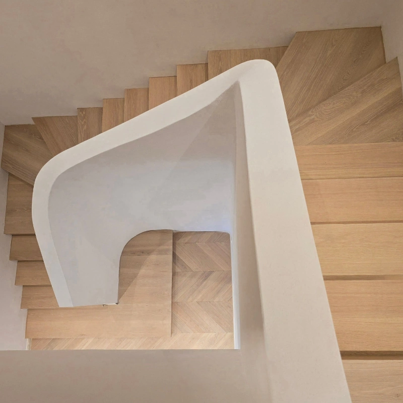 Top-down view of wood-tread stairs transitioning into a Chevron floor